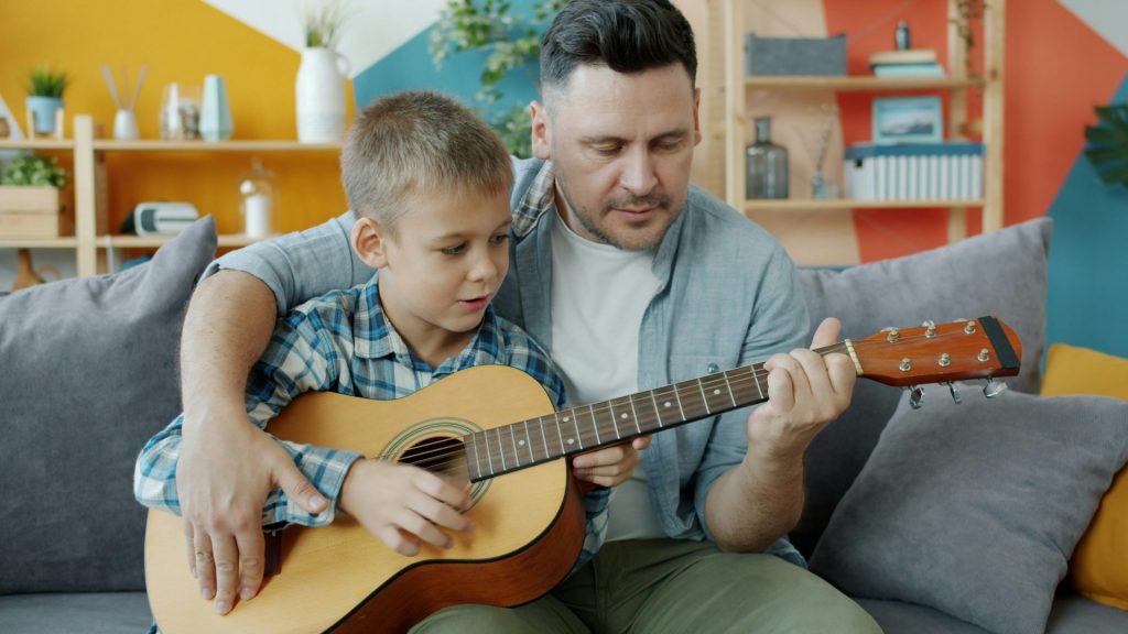 Vater und Sohn spielen gemeinsam Gitarre