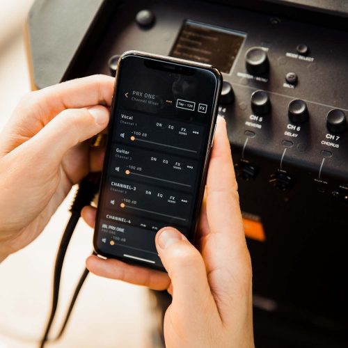 Hand hält Smartphone vor Audiomischer