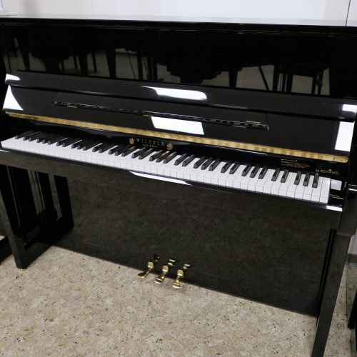 Schwarzes Klavier mit Klaviertasten und Pedalen.